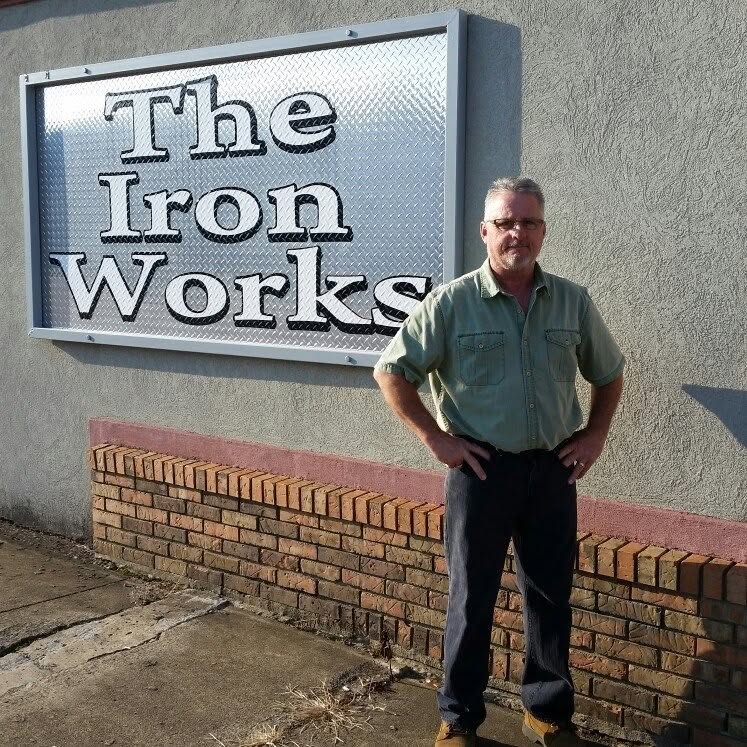 Don Clifton in front of The Iron Works sign on East Center Street